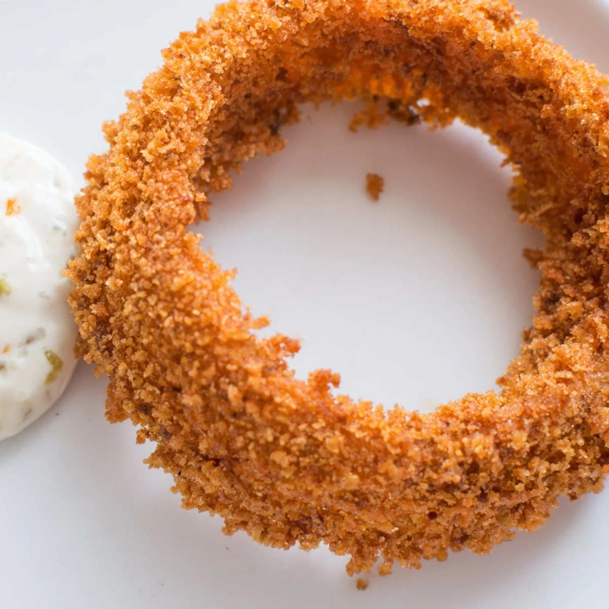 A basket of Crispy Air Fryer Onion Rings with Burger Sauce paired with fries makes an appetizing lunch.