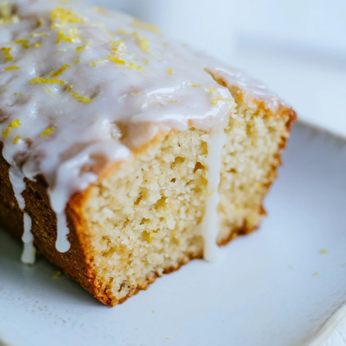 Lemon Bread Loaf cooling on rack, vibrant glaze dripping, ready for a cozy breakfast or snack.