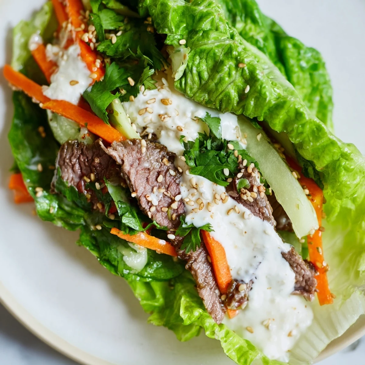 A close-up of a Beef Wrap with Lettuce featuring tender marinated beef slices nestled in crisp green lettuce leaves.