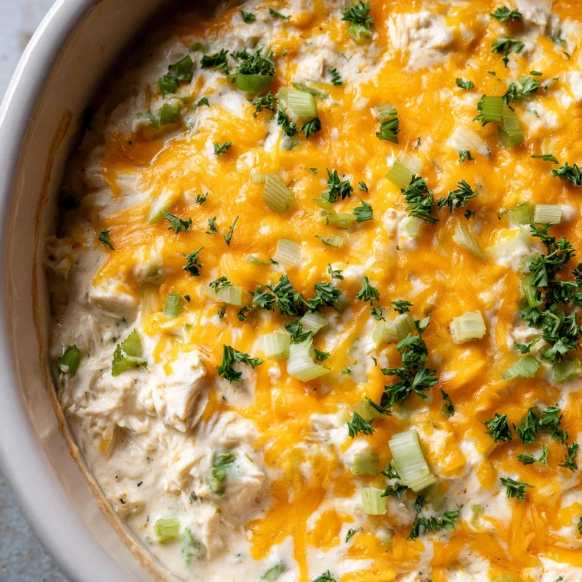 Golden, bubbly Cajun Crab Dip with crackers is baked to perfection and garnished with fresh parsley for a spicy party appetizer.