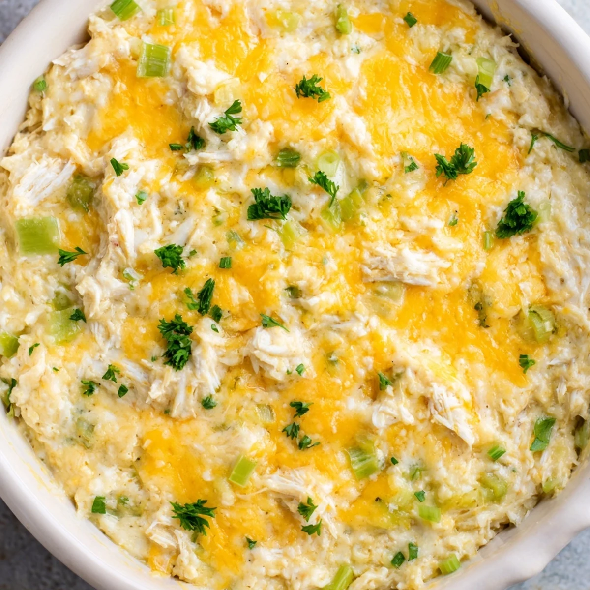 Creamy Cajun Crab Dip with crackers is served warm in a dish, featuring rich cheese and tender crab meat for dipping.