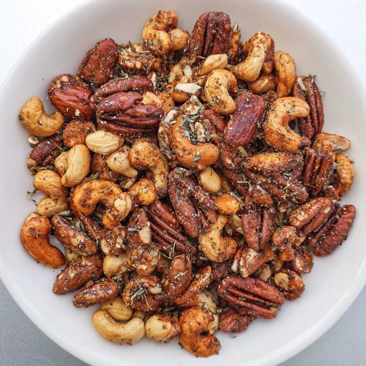Homemade Creole Spiced Nuts Mix spilling from a mason jar, a perfect party snack.