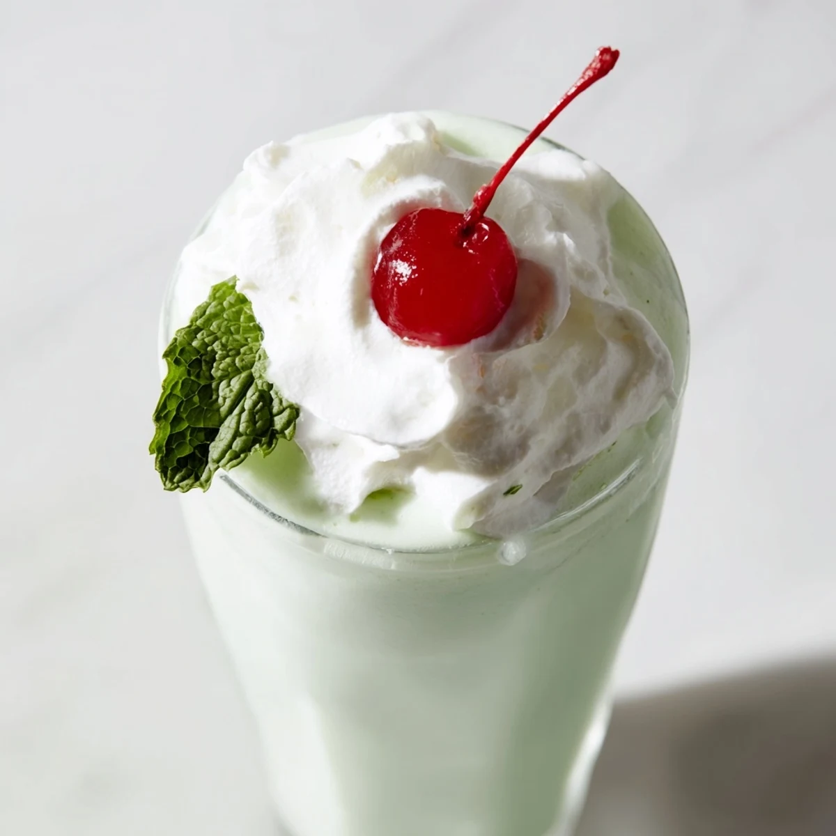 Cool, creamy Mint Milkshake with Maraschino Cherry and fresh mint garnish, served in a chilled glass.