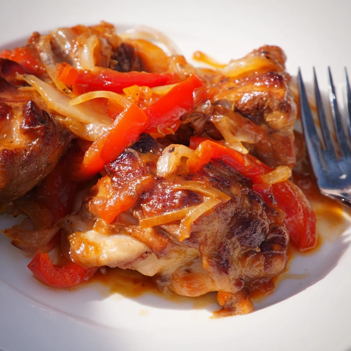 Golden-brown chicken thighs simmer in tangy-sweet Catalina dressing with onions and peppers in a skillet.