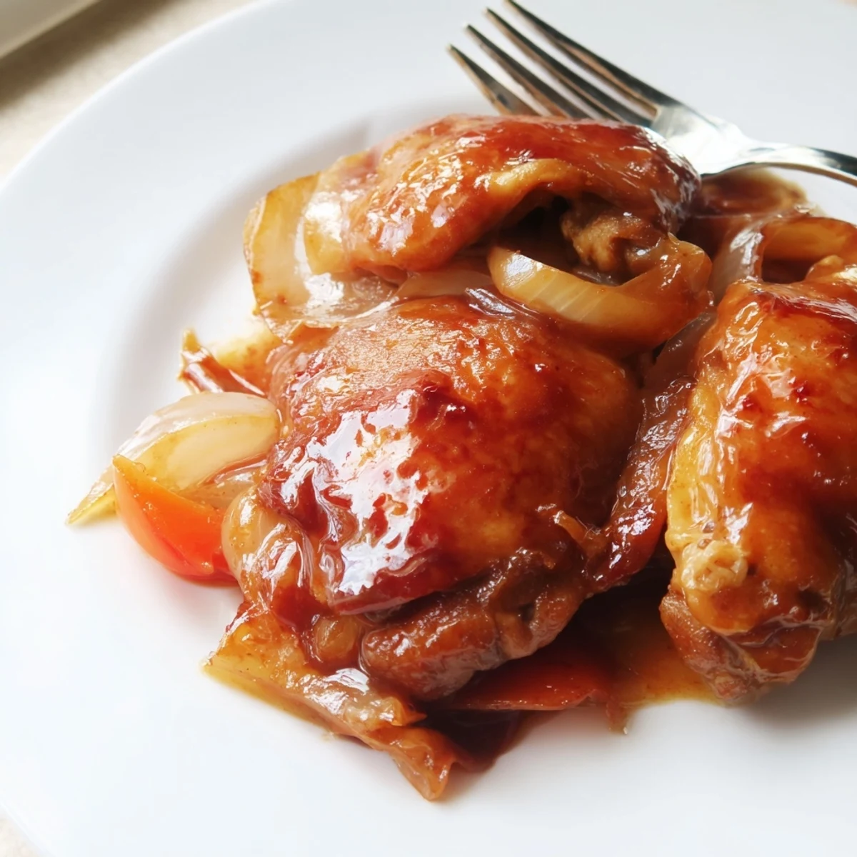 Braised Catalina Chicken is served over fluffy rice, glistening with a thick, glossy sauce.