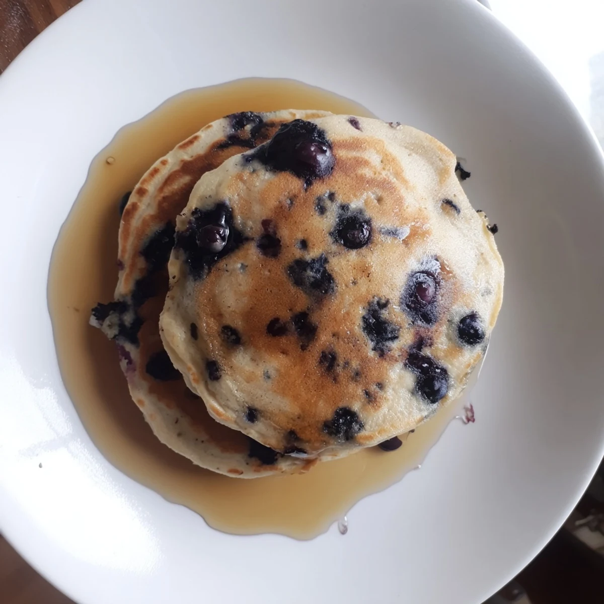 Fluffy Greek Yogurt Blueberry Pancakes stacked high with golden edges and fresh berries.
