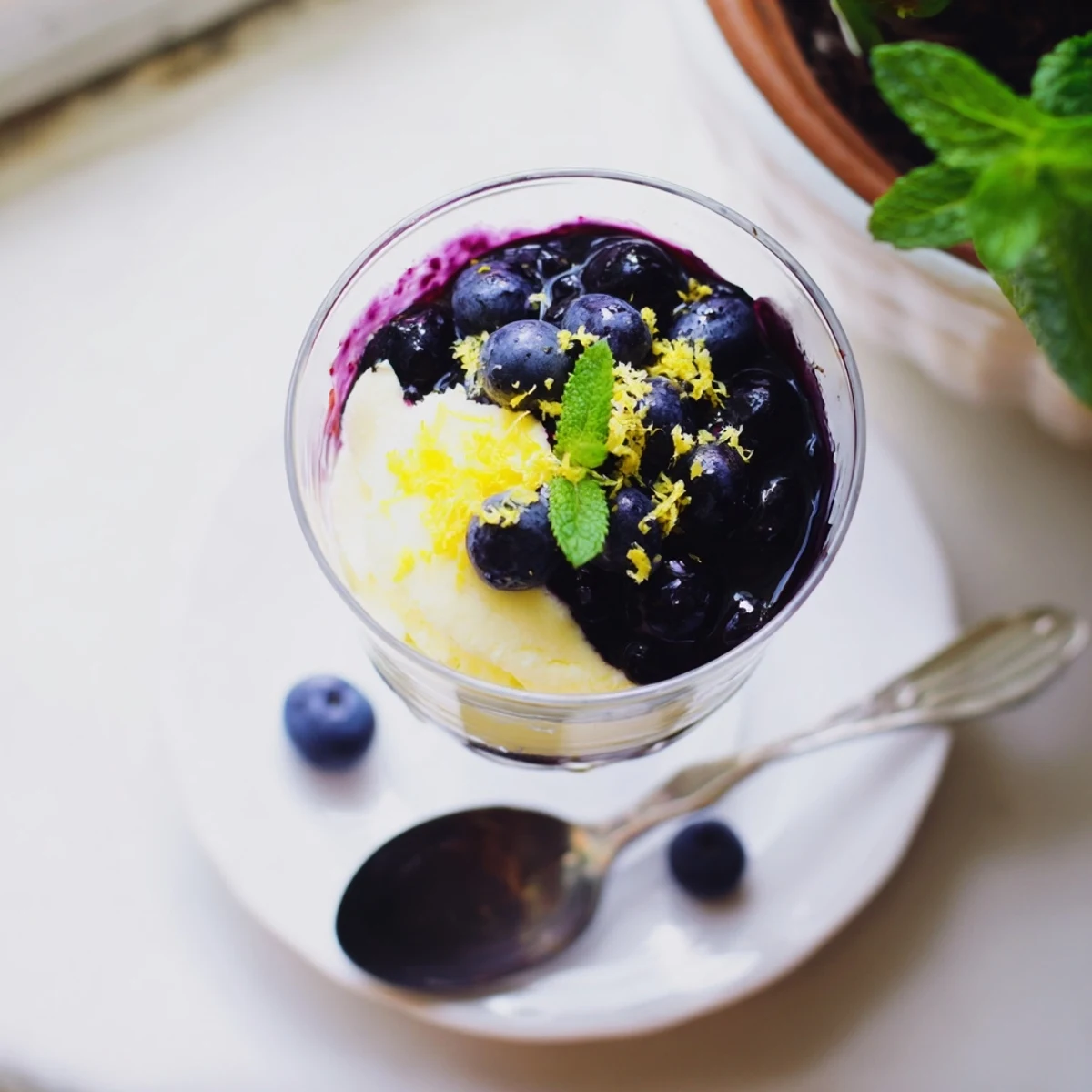 Spoonful of Lemon Blueberry Mousse revealing creamy lemon curd and sweet blueberry swirls, garnished with zest.