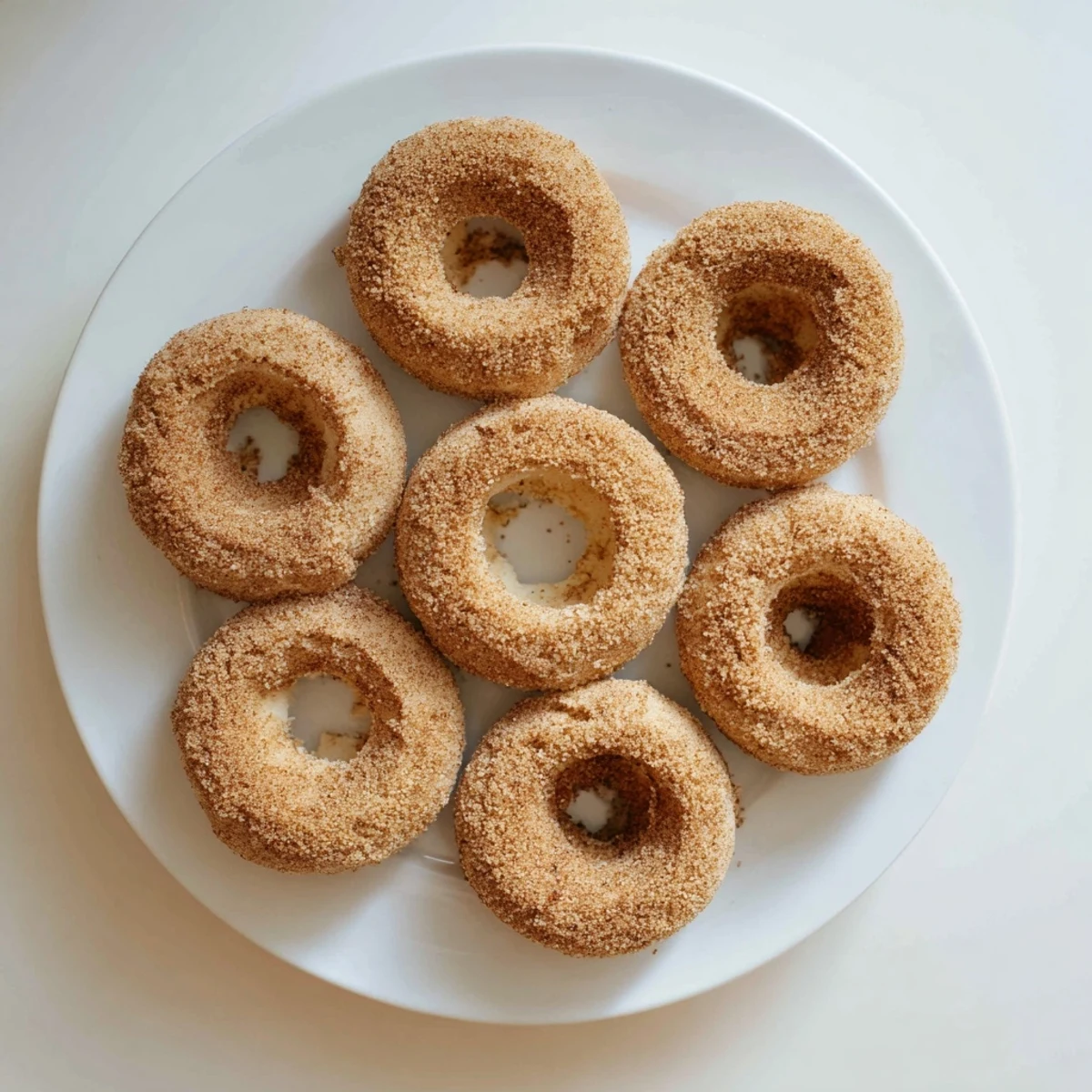 Close-up of Delicious Baked Cinnamon Sugar Donuts You Can’t Resist with a fluffy interior and glistening cinnamon sugar topping on a rustic plate.