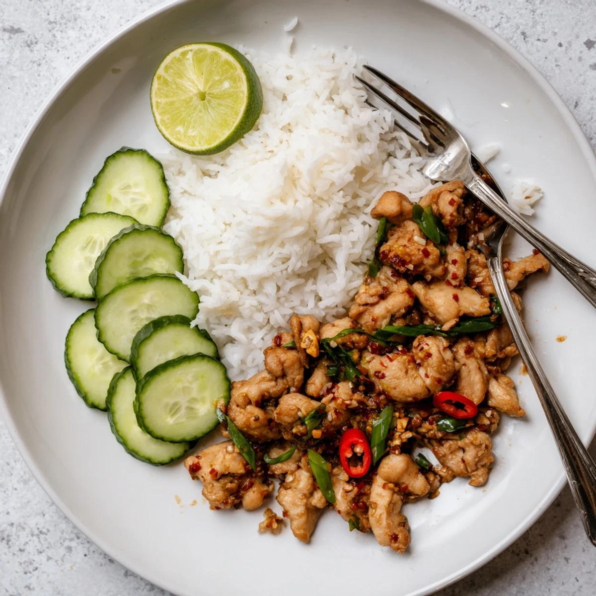 Stir-fried Vietnamese Lemongrass Chicken in a skillet, emitting aromatic steam, ready to be enjoyed with steamed rice and a side of fresh vegetables.