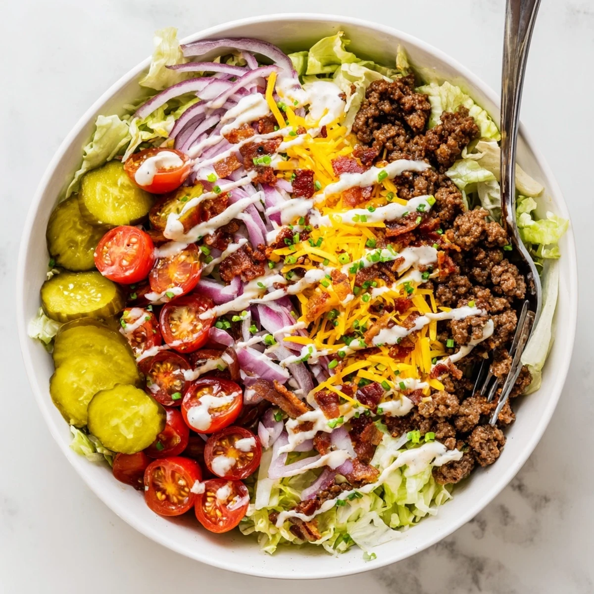 Drizzling creamy Smash Sauce over a loaded Smash Burger Bowl garnished with sesame seeds and chives.