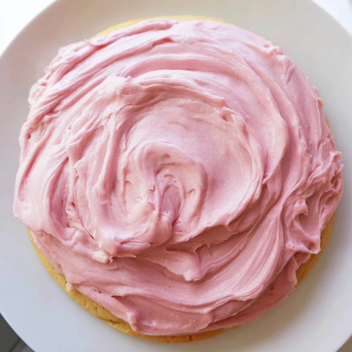 Giant Chilled Crumbl Sugar Cookies with soft centers and pink frosting on a marble counter.