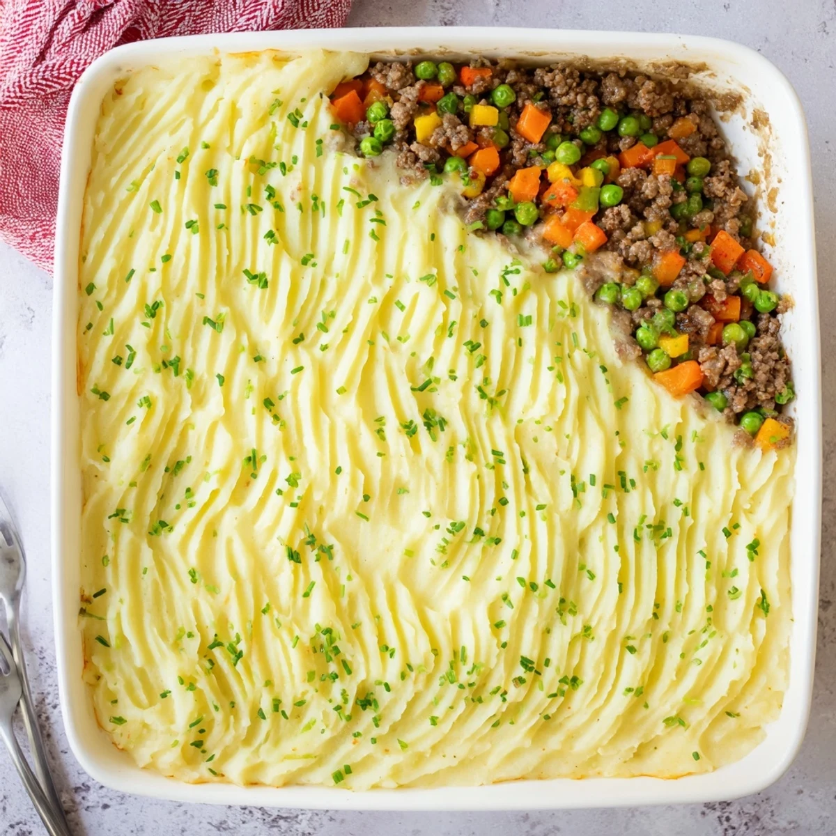 Golden-brown Shepherd's Pie with Creamy Garlic Mashed Potatoes bubbling in a baking dish, topped with fresh parsley.