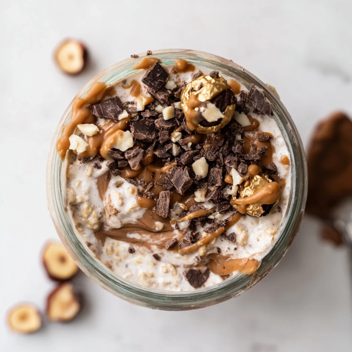 Decadent Ferrero Rocher Protein Overnight Oats with Greek yogurt, protein powder, and a drizzle of hazelnut butter.