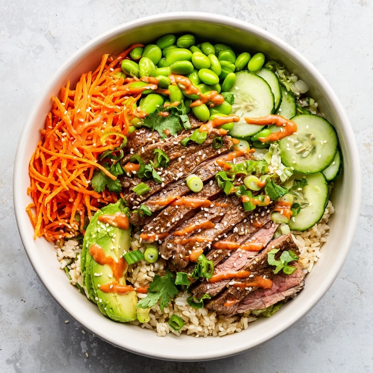 Protein-packed flank steak bowl with marinated grilled meat, edamame, cilantro, and zesty lime-spiced sauce