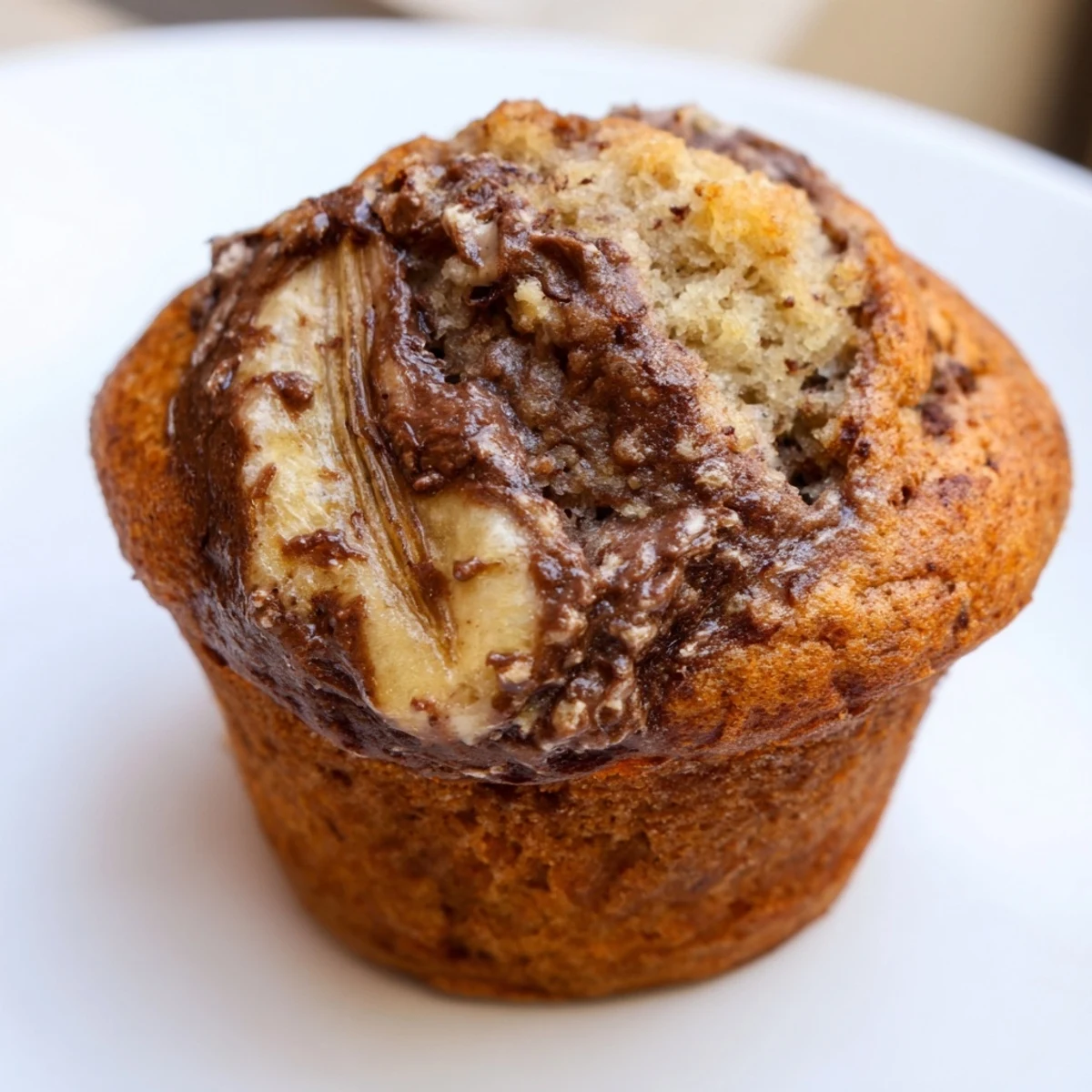 Moist breakfast muffins featuring sweet banana batter swirled with creamy chocolate hazelnut spread