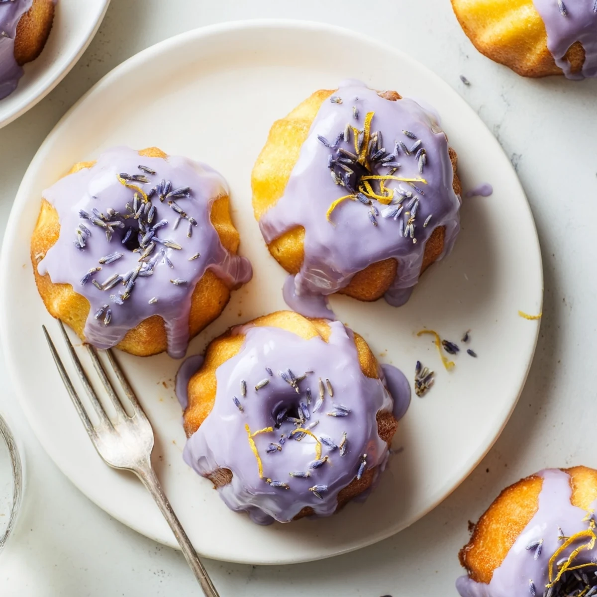 Golden mini lemon cakes drizzled with purple lavender glaze and sprinkled with dried lavender buds
