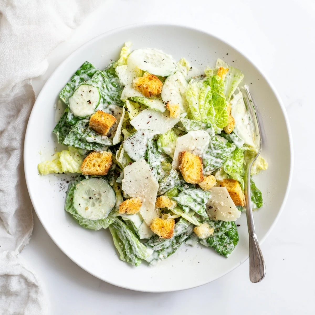 Crisp cucumber Caesar salad topped with homemade dressing, crunchy croutons, and shaved Parmesan