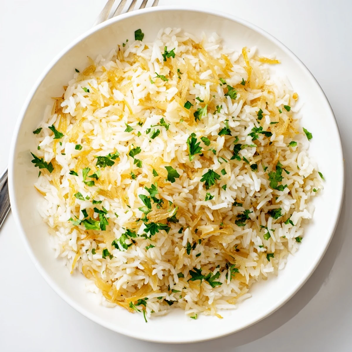 Savory French onion butter rice garnished with chopped parsley and grated cheese on a rustic wooden table