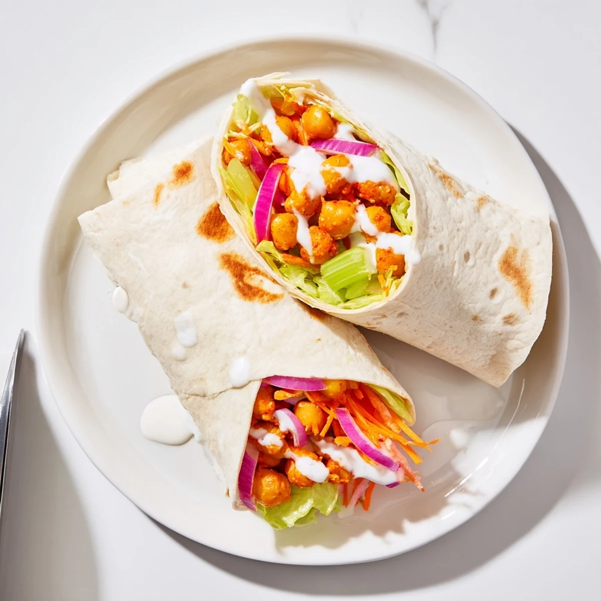 Golden buffalo chickpea wraps filled with crisp vegetables and creamy ranch dressing