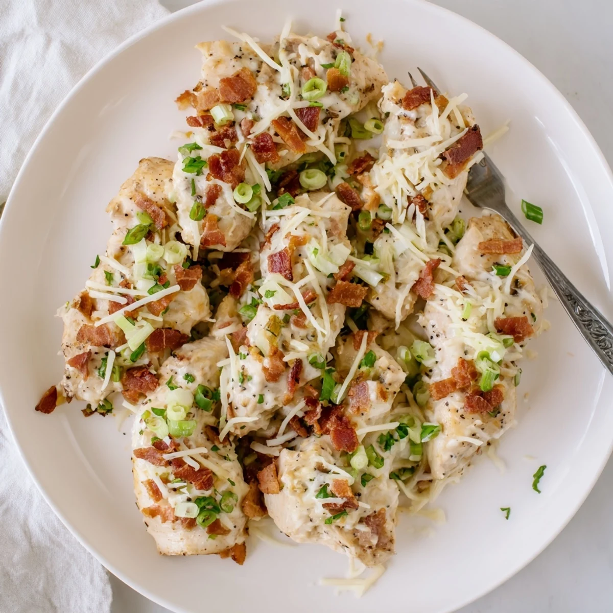 Tender slow-cooked chicken in creamy Parmesan mozzarella mixture garnished with fresh herbs