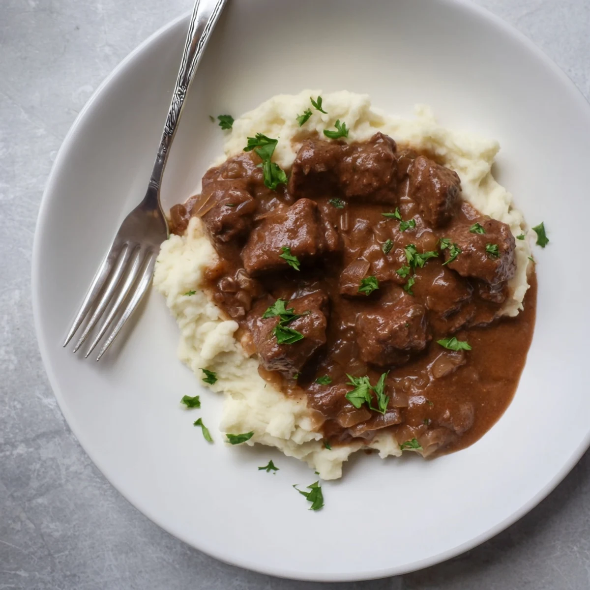 Fork-tender beef pieces swimming in rich savory gravy after hours of slow cooking perfection