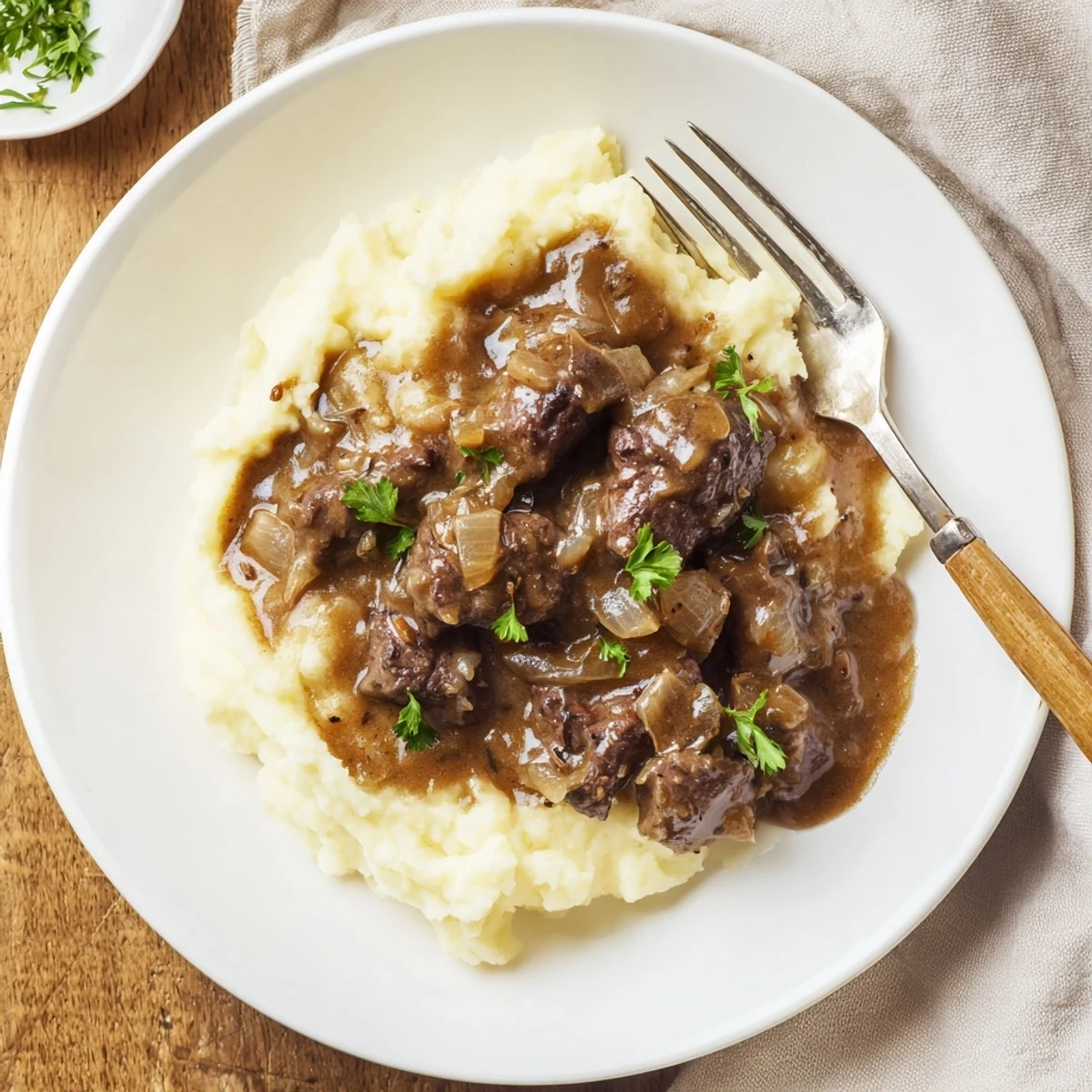 Golden brown beef tips and gravy dish plated alongside fluffy white mashed potatoes for a comforting dinner