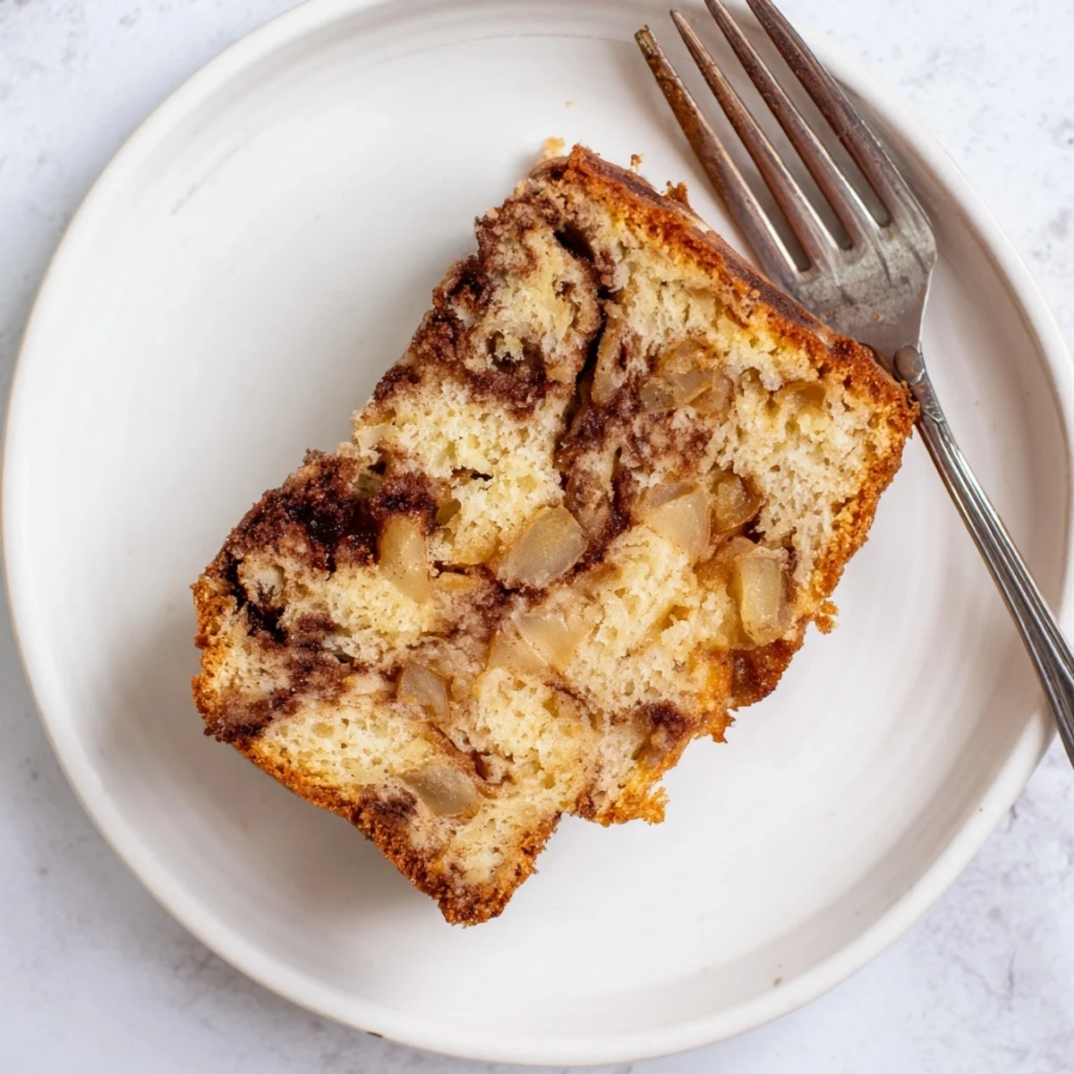 Homemade cinnamon apple bread served on wooden board with powdered sugar dusting
