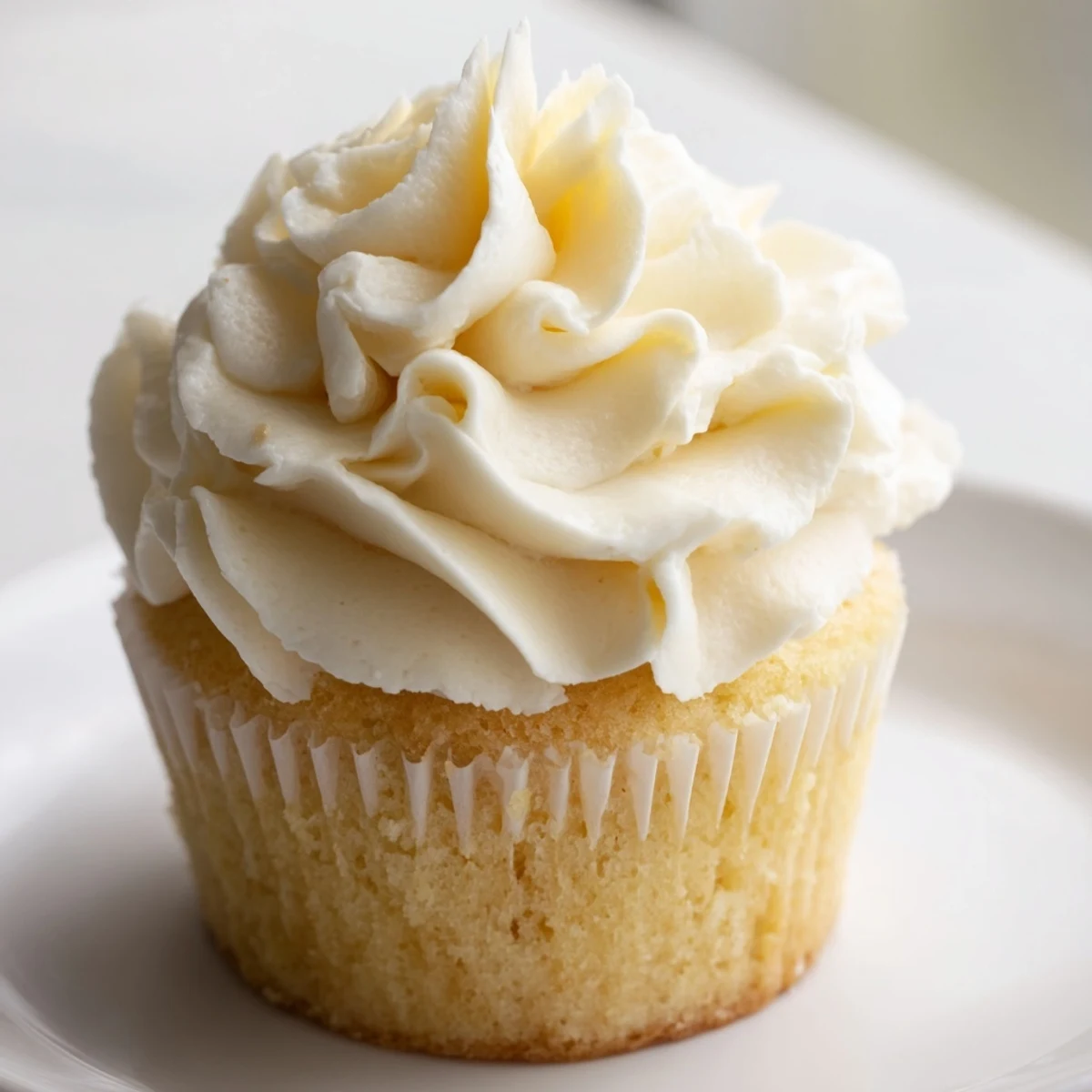 Light and moist vanilla cupcakes with sweet buttercream served on a decorative cake stand