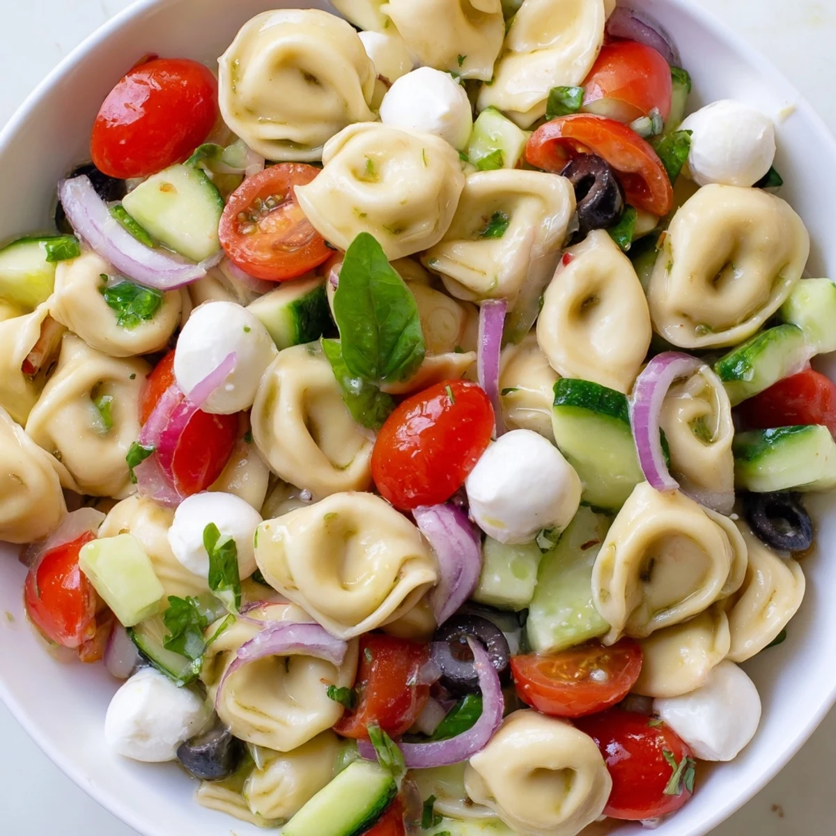 Creamy cheese tortellini pasta salad tossed with crisp vegetables and fresh basil