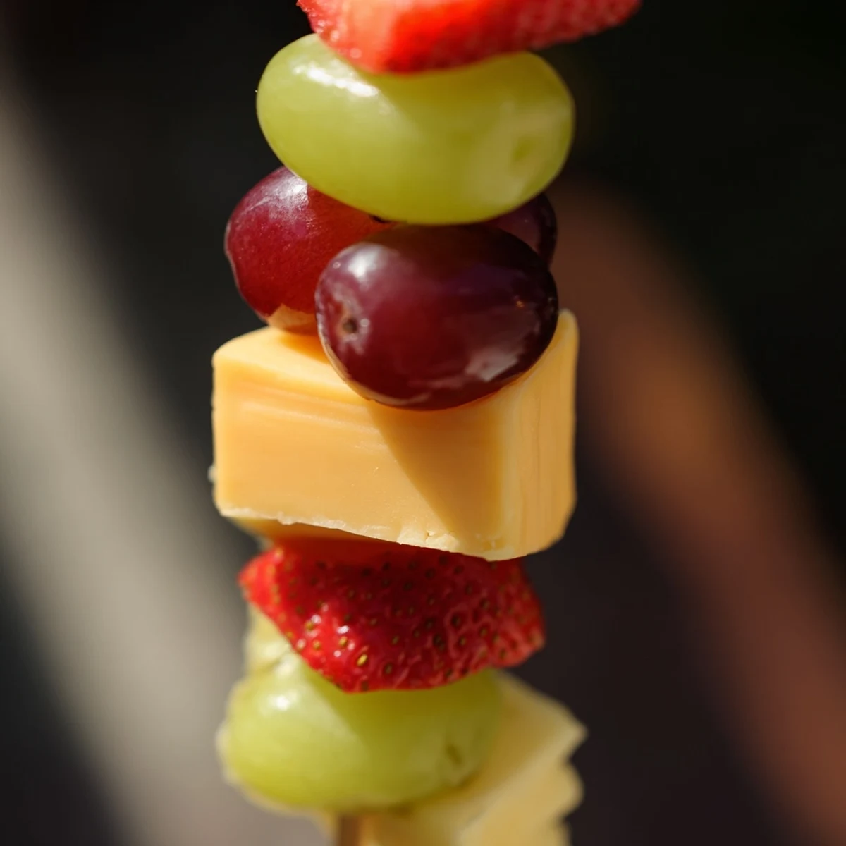 Colorful fruit and cheese kabobs featuring fresh grapes pineapple strawberries and creamy cheese cubes