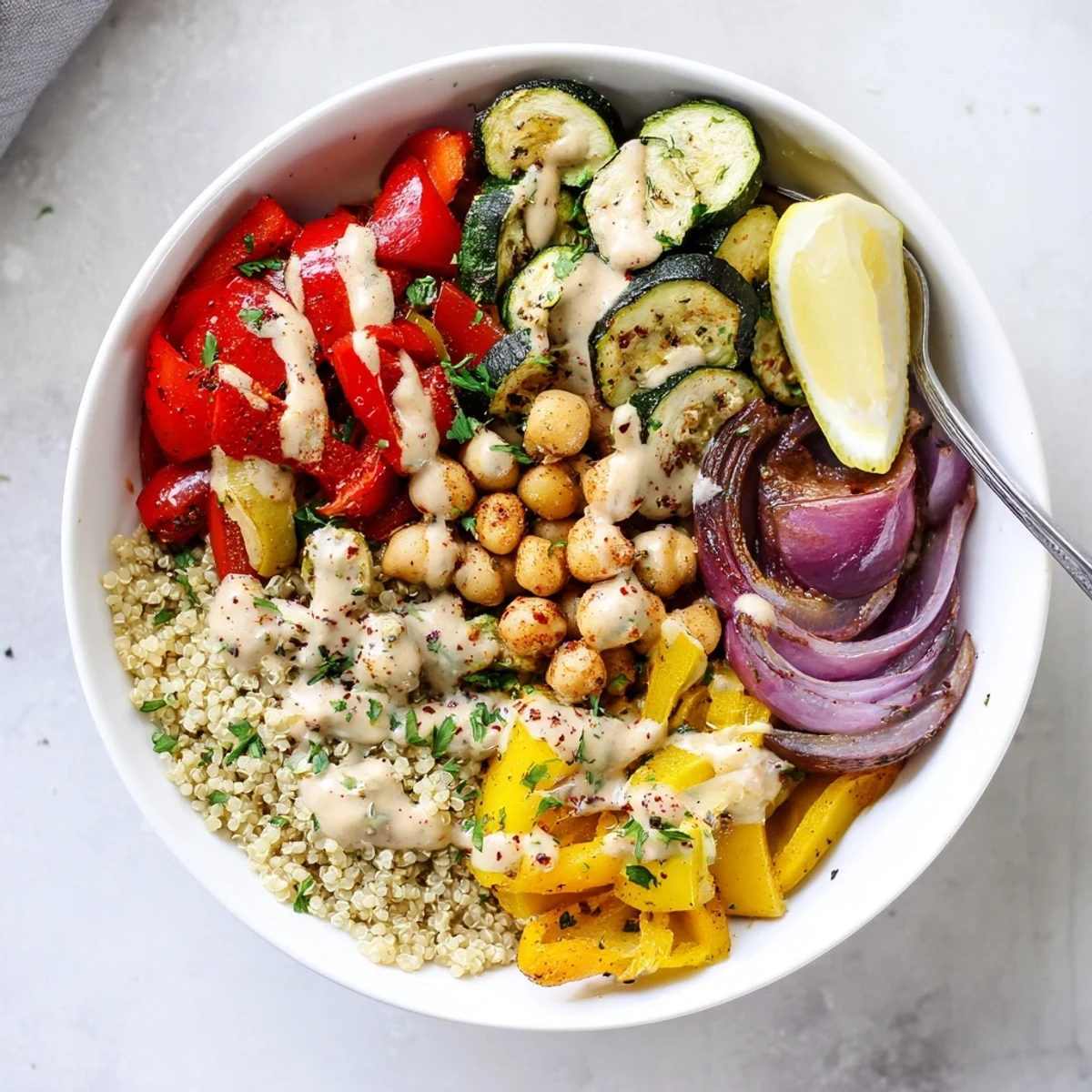 Golden roasted zucchini, eggplant, and chickpeas in a vegan Mediterranean roasted vegetables bowl drizzled with creamy tahini dressing.