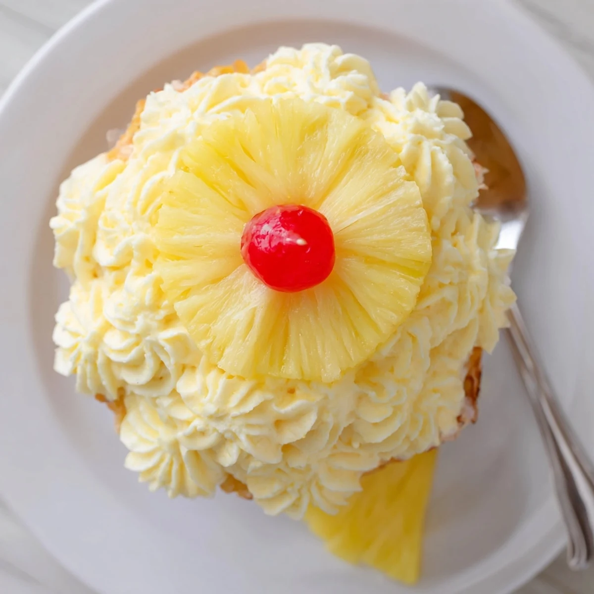 Dole Whip Cupcakes Recipe topped with fluffy pineapple frosting and dried pineapple petals.