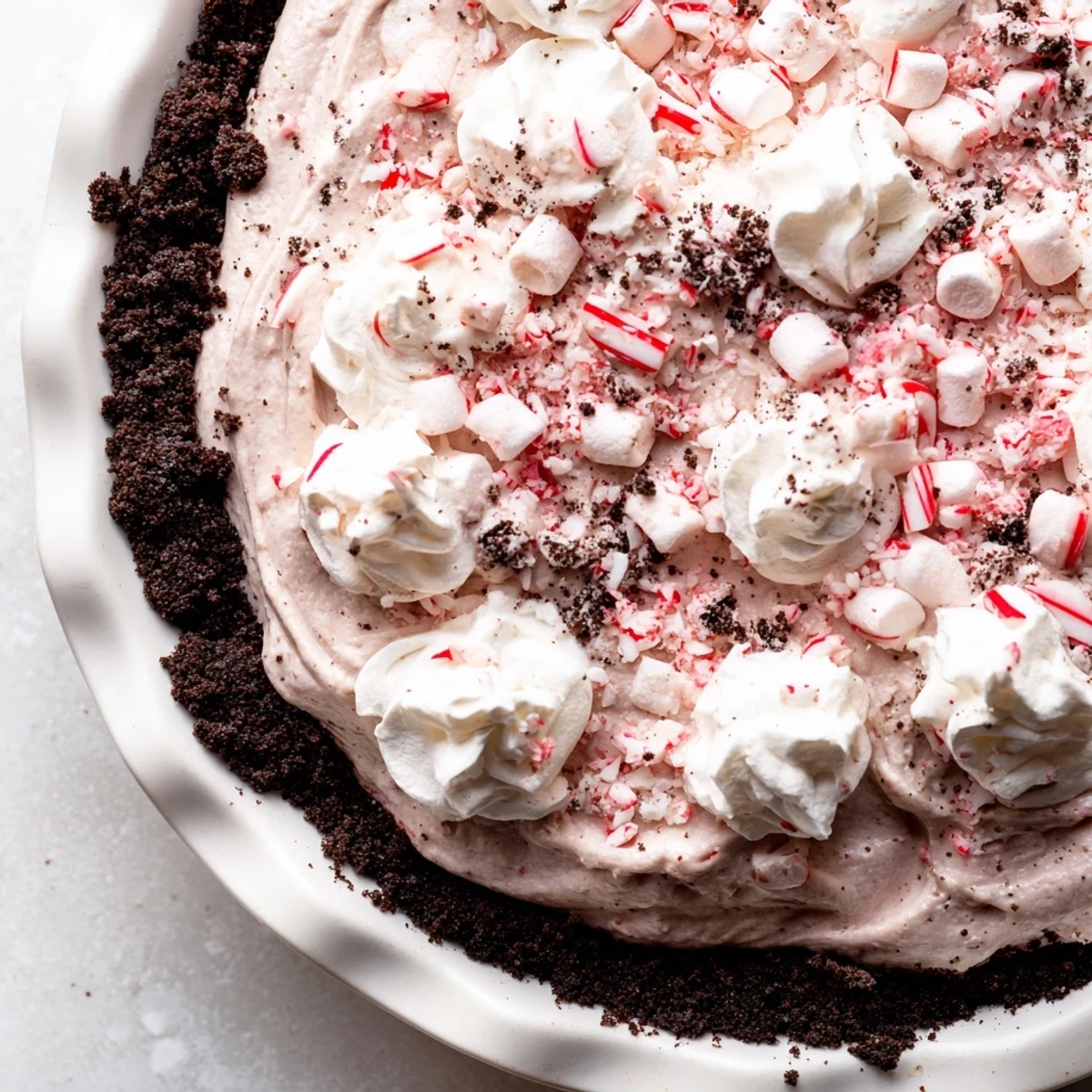 No-bake Candy Cane Pie chilled overnight, pale pink filling studded with marshmallows