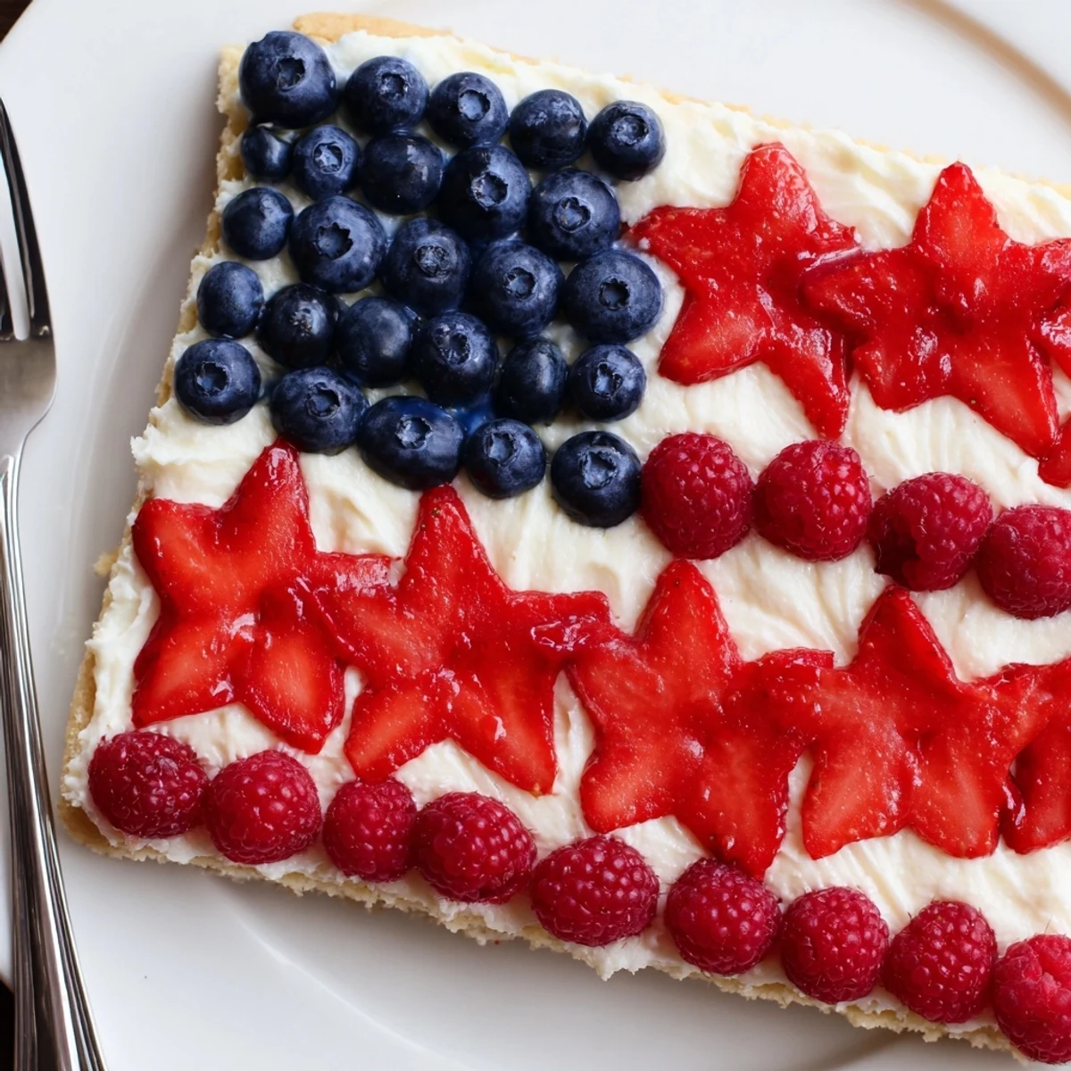 Sugar Cookie Flag Fruit Pizza with glossy cream cheese frosting and juicy berries