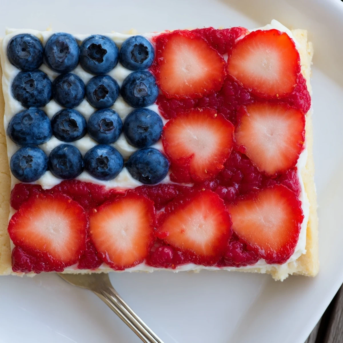 Baked Sugar Cookie Flag Fruit Pizza on platter, creamy frosting and fresh berries
