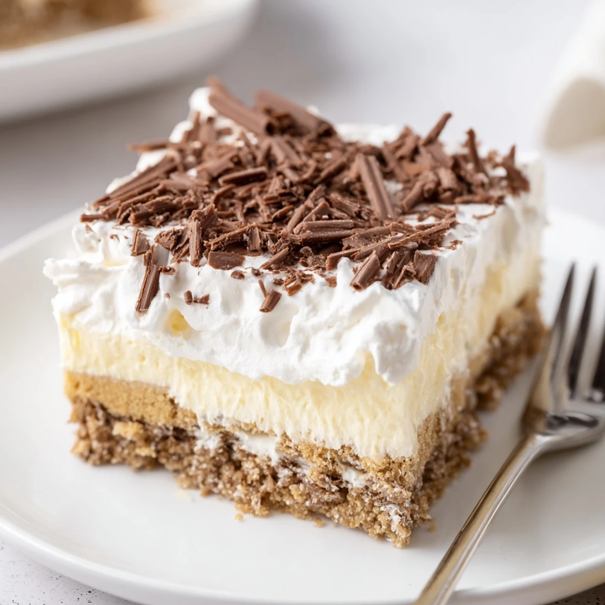 Chilled No Bake Layered Dessert sliced in dish, graham cracker base visible