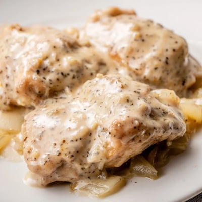 Tender slow cooker chicken thighs coated in a luscious homemade white cream gravy