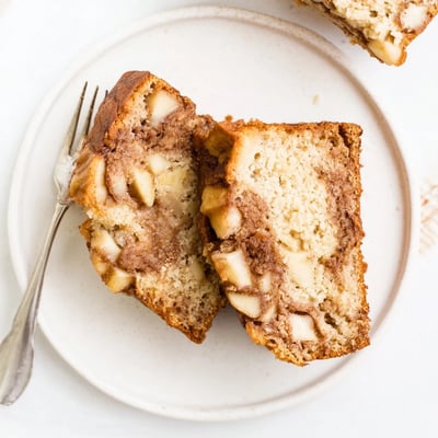 Sliced cinnamon apple bread revealing moist texture and diced apple pieces throughout